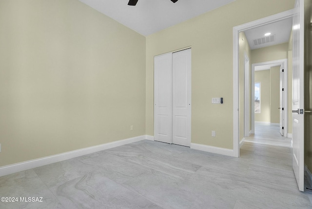 unfurnished bedroom featuring ceiling fan and a closet