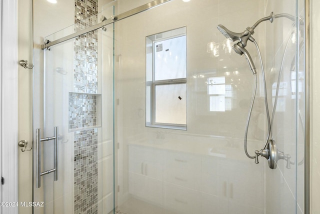 bathroom with a shower with door