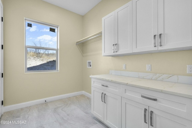 clothes washing area with cabinets and washer hookup