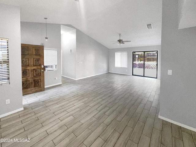 unfurnished living room featuring a textured ceiling, light hardwood / wood-style floors, ceiling fan, and lofted ceiling