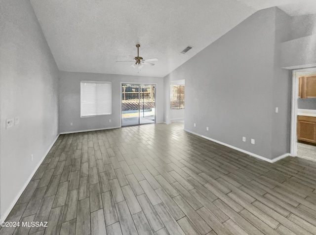 unfurnished living room featuring hardwood / wood-style floors, a textured ceiling, ceiling fan, and lofted ceiling