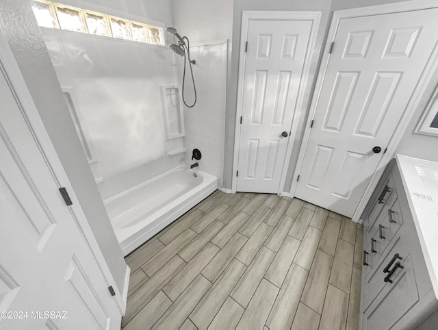 bathroom with vanity, washtub / shower combination, and hardwood / wood-style flooring