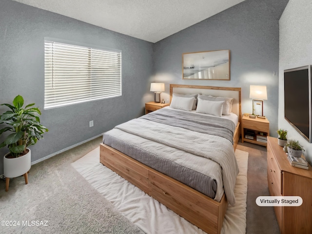 bedroom with a textured ceiling, light colored carpet, and lofted ceiling