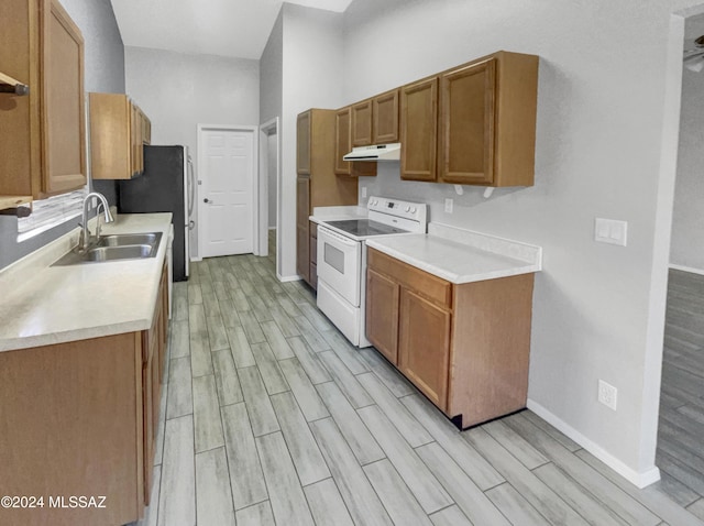 kitchen featuring stainless steel fridge, white electric range, sink, and light hardwood / wood-style flooring