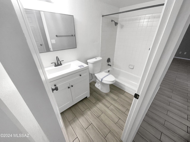 full bathroom with toilet, hardwood / wood-style floors, vanity, and tiled shower / bath combo