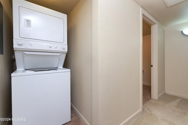 laundry area with light colored carpet and stacked washer / dryer