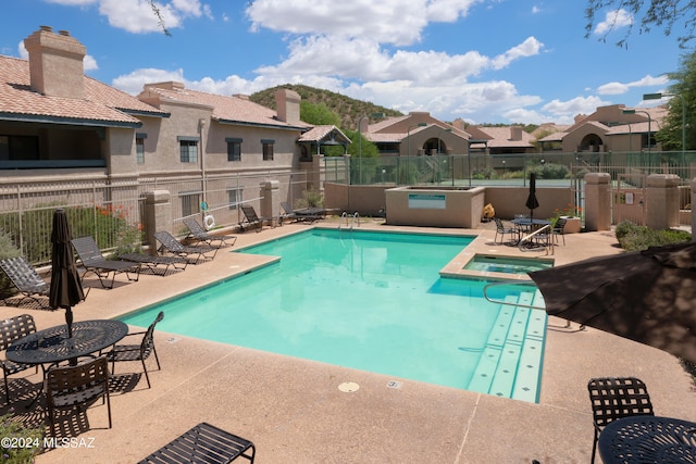 view of pool featuring a patio and a hot tub