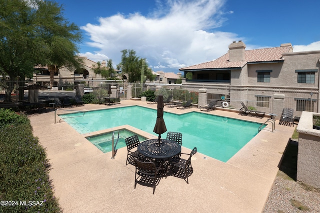 view of pool with a community hot tub and a patio area