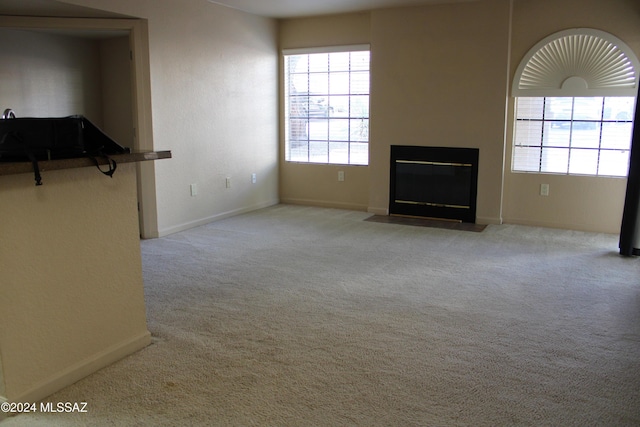 unfurnished living room with light colored carpet