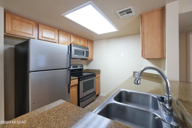 kitchen featuring sink, stainless steel appliances, and light brown cabinets