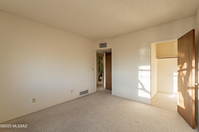 carpeted empty room with a textured ceiling