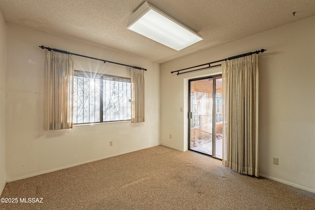 empty room featuring a textured ceiling and carpet floors