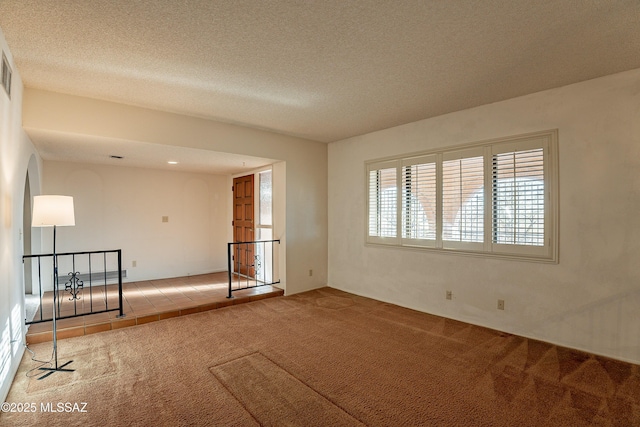 carpeted spare room with a textured ceiling