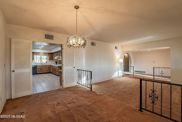 interior space featuring sink, a textured ceiling, and a notable chandelier