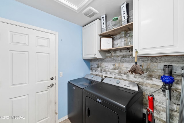 laundry room with cabinets and washing machine and clothes dryer