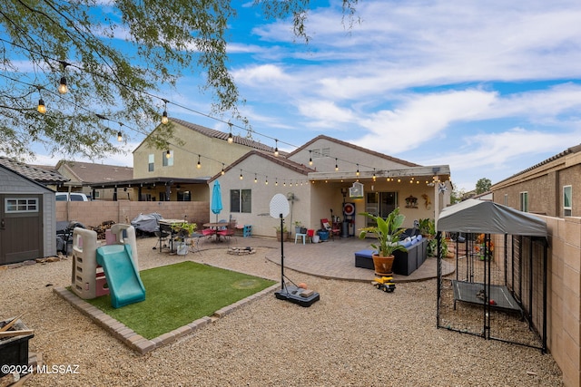 back of house with a patio and a storage shed