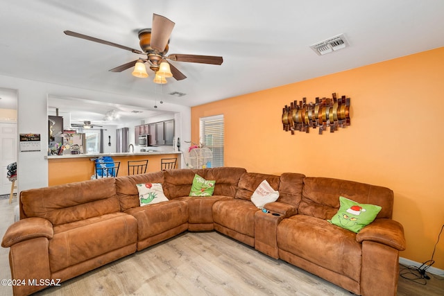 living room featuring light hardwood / wood-style floors and ceiling fan