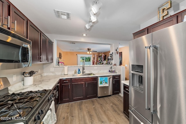 kitchen featuring ceiling fan, sink, light hardwood / wood-style floors, and appliances with stainless steel finishes