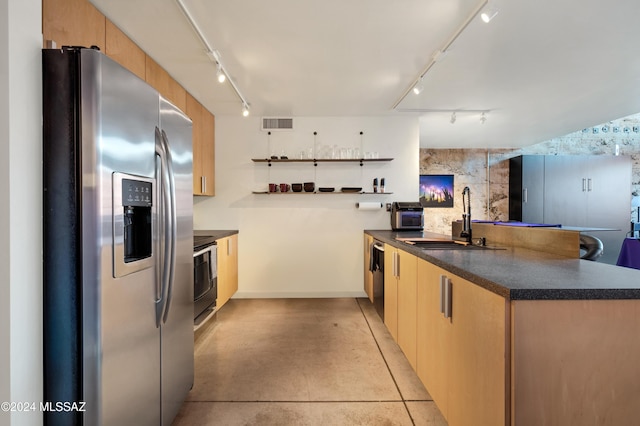 kitchen with appliances with stainless steel finishes, sink, and kitchen peninsula