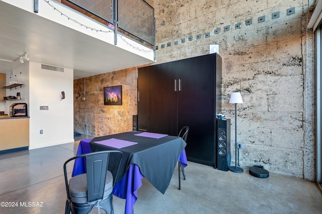 dining space featuring concrete floors and a high ceiling