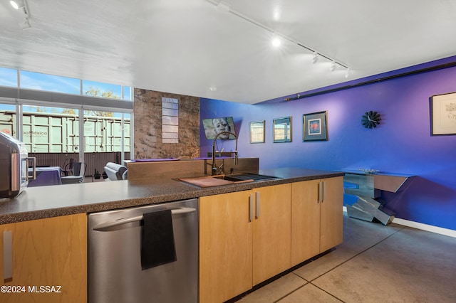 kitchen featuring light tile patterned flooring, stainless steel dishwasher, rail lighting, and sink