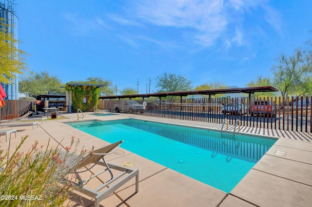 view of swimming pool with a patio and an in ground hot tub