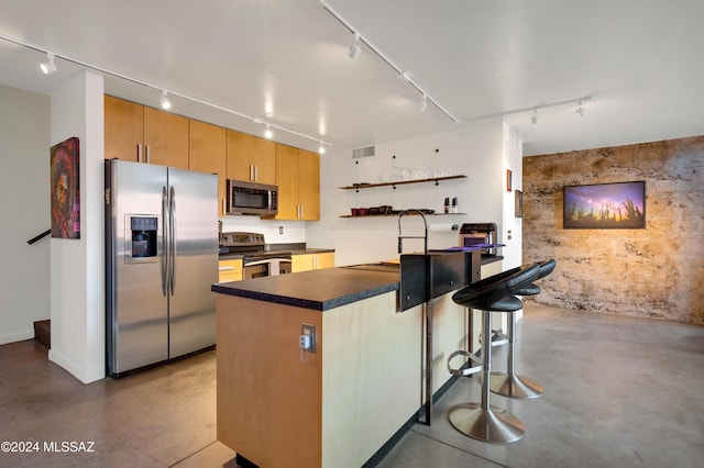 kitchen with a kitchen bar, sink, kitchen peninsula, and appliances with stainless steel finishes