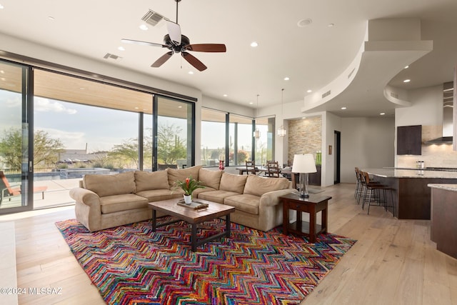 living room with light wood-type flooring and ceiling fan