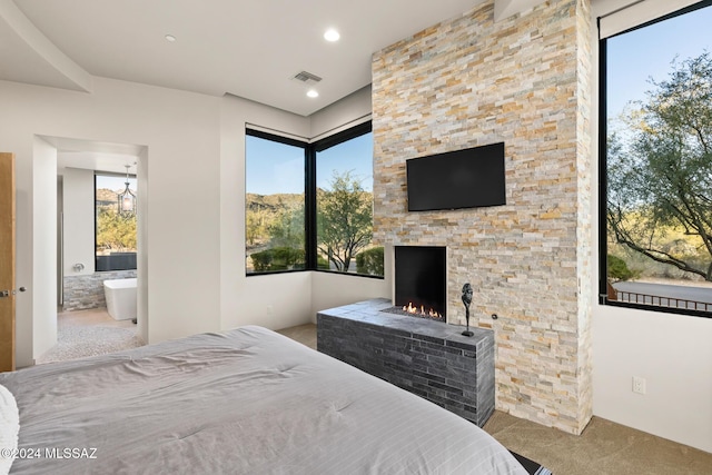 carpeted bedroom with a fireplace and ensuite bathroom