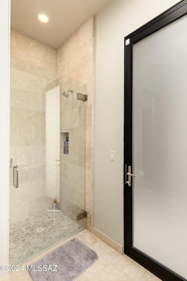 bathroom featuring tile patterned flooring and an enclosed shower