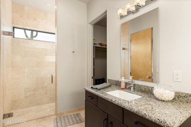 bathroom with tile patterned floors, vanity, and an enclosed shower