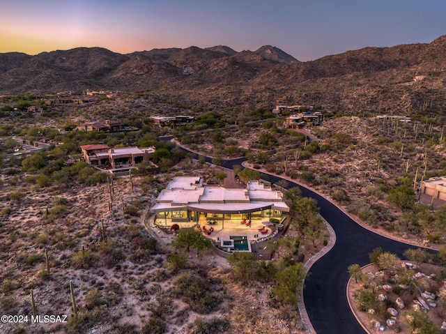 aerial view at dusk featuring a mountain view