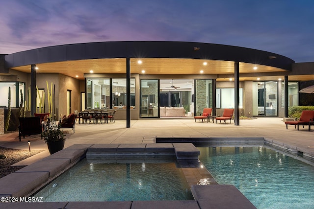 back house at dusk featuring a patio