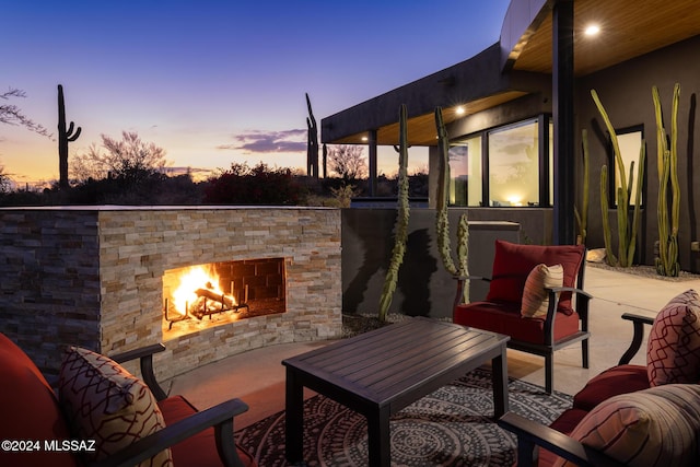 patio terrace at dusk with an outdoor stone fireplace