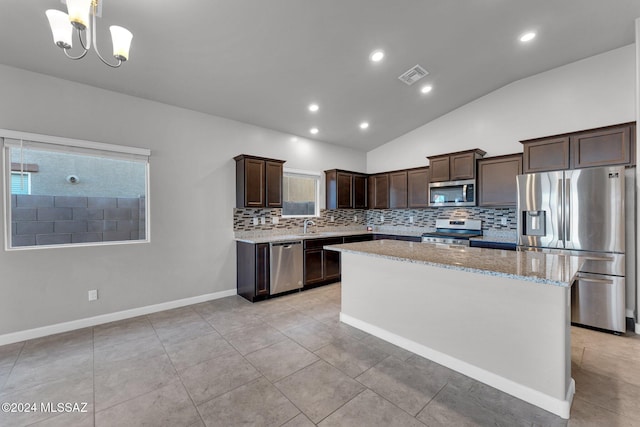 kitchen with a center island, tasteful backsplash, sink, stainless steel appliances, and lofted ceiling