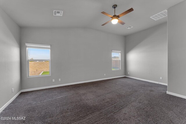 bedroom with ceiling fan, dark carpet, and vaulted ceiling