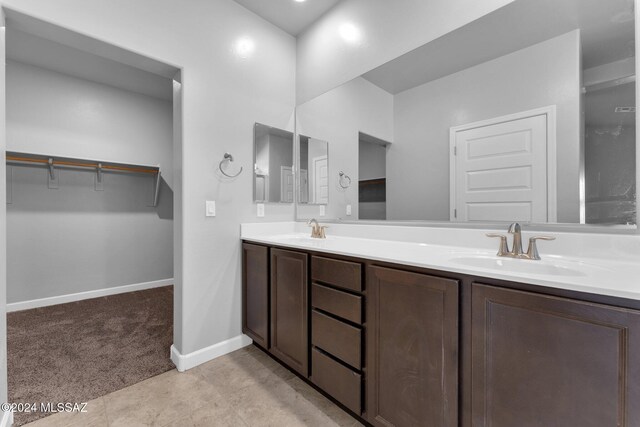 bathroom featuring a shower with shower door and vanity