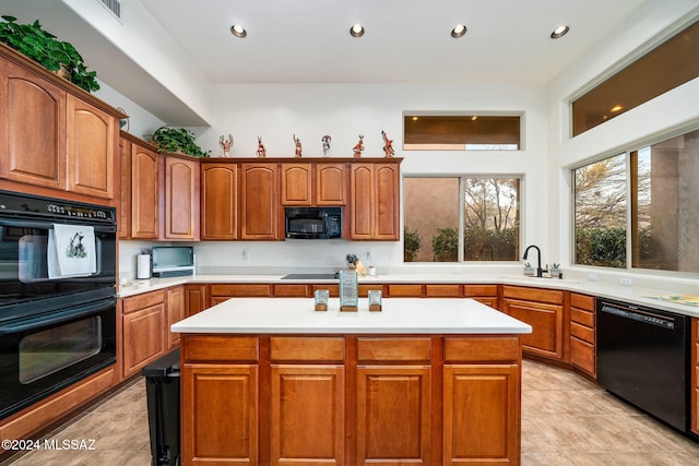 kitchen with light tile patterned flooring, sink, a kitchen island, and black appliances