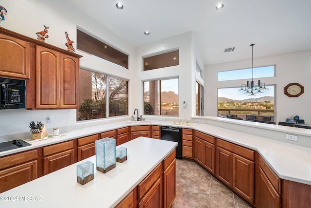 kitchen with black appliances, a notable chandelier, pendant lighting, and sink