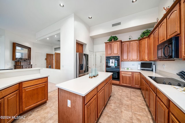 kitchen featuring black appliances, a kitchen island, and light tile patterned flooring