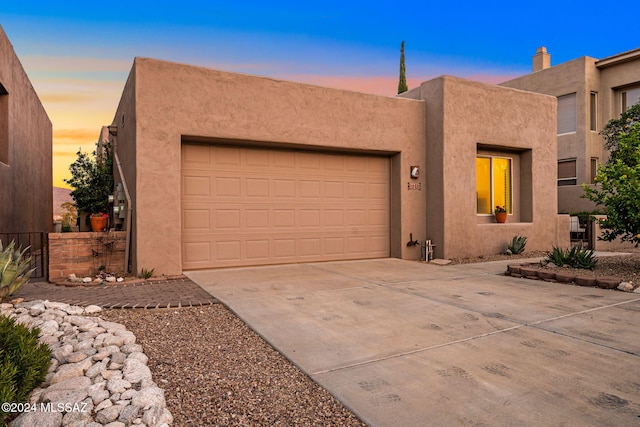 pueblo revival-style home featuring a garage