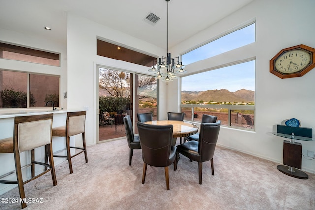 carpeted dining room with a mountain view, plenty of natural light, and a chandelier