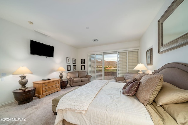 bedroom featuring access to exterior and light carpet