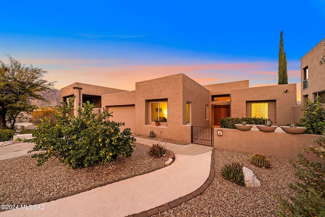 pueblo revival-style home featuring a garage