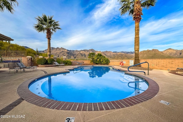 view of pool with a mountain view and a patio