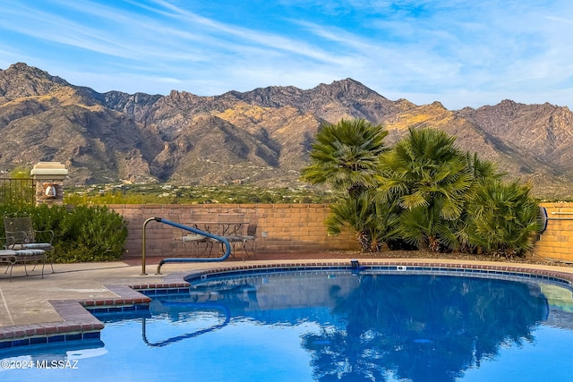 view of pool with a mountain view and a patio