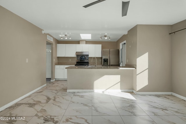 kitchen featuring white cabinetry, sink, rail lighting, tasteful backsplash, and appliances with stainless steel finishes