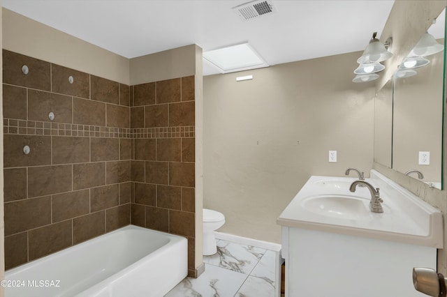 full bathroom featuring vanity, tiled shower / bath combo, and toilet