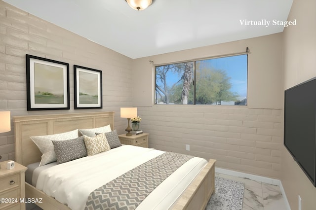 bedroom featuring brick wall