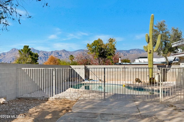 exterior space featuring a mountain view, a fenced in pool, and a patio area